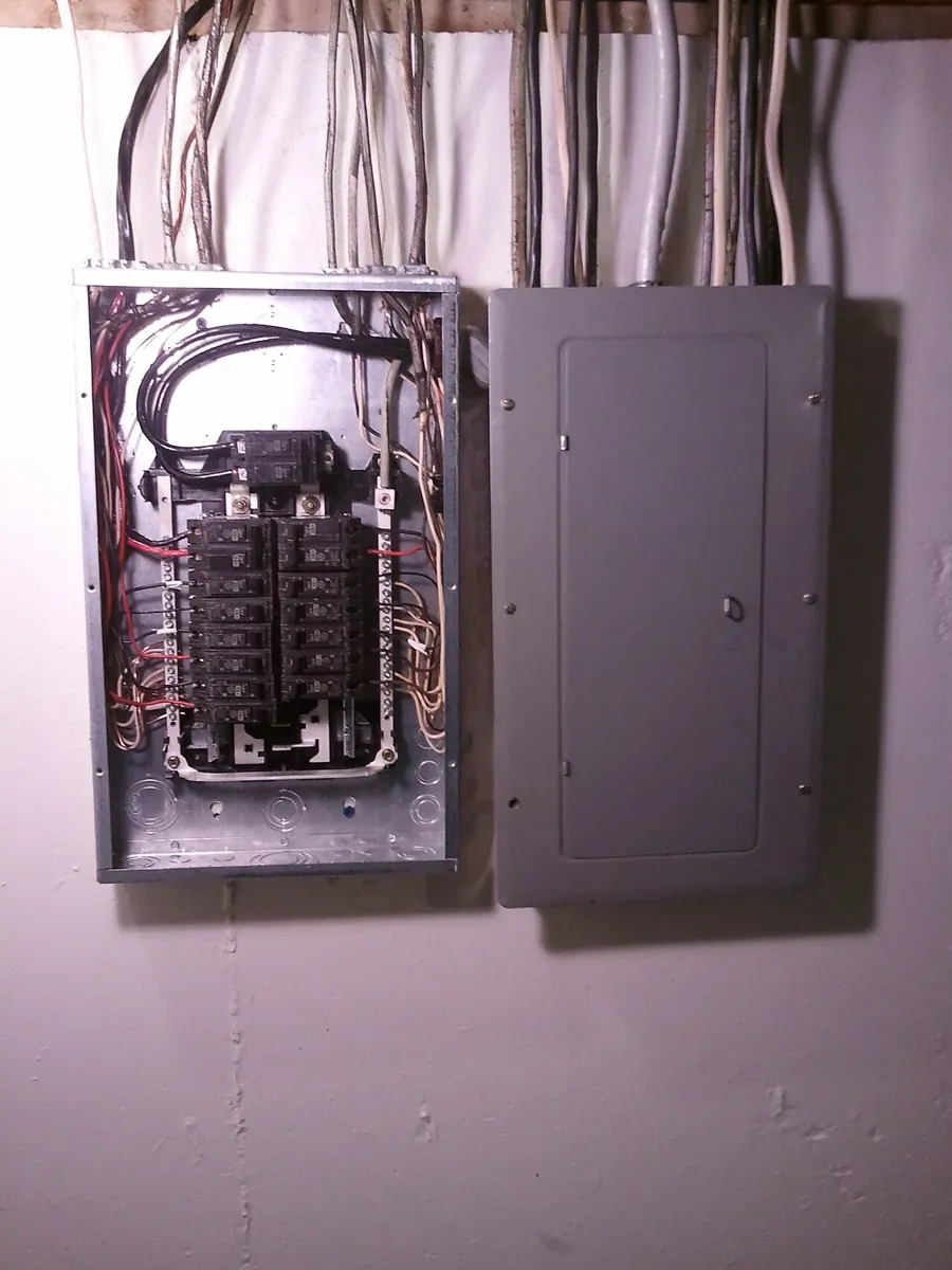 Residential electrical breaker panel and subpanel with covers removed