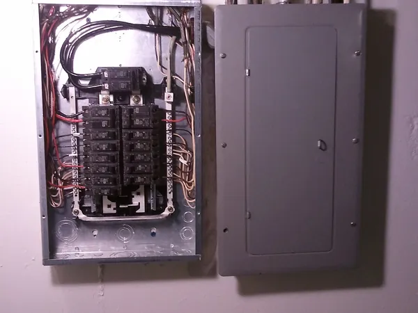 Residential electrical breaker panel and subpanel with covers removed